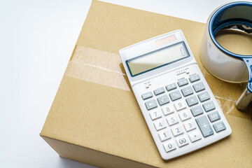 梱包されたダンボール箱と電卓