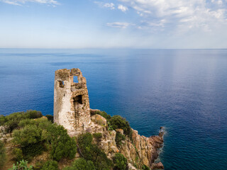 Fototapeta na wymiar San Gemiliano fortress tower on the rocky coast on the blue sea. Sardinia, Italy. City of Arbatax.