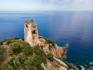 Fototapeta na wymiar San Gemiliano fortress tower on the rocky coast on the blue sea. Sardinia, Italy. City of Arbatax.