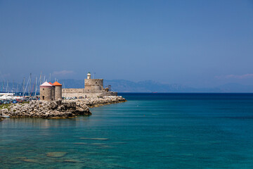 ギリシャ　ロードス島のロードスのマンドラキ港に建つ聖ニコラス要塞と風車