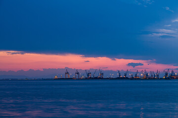 ギリシャ　夕焼けでオレンジに染まった空とテッサロニキから見えるエーゲ海のテルメ湾とテッサロニキ港