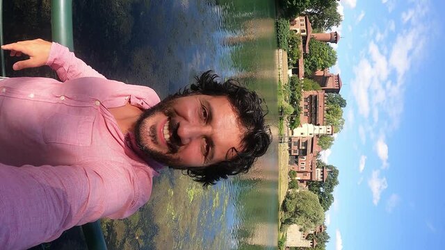 happy tourist visiting Turin (Torino), piedmont, Italy. Happy man take selfi photo with Borgo Medieval village and fortress of Turin and river Po. Fisheye lens 