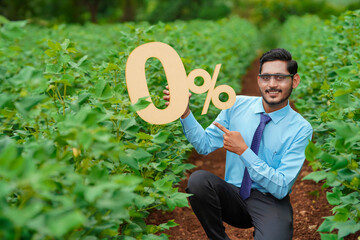 Young indian agronomist or financier showing zero percent sign or symbol at agriculture field