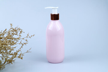 Pink bottle with pump on white background