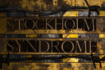 Stockholm Syndrome text on vintage textured grunge copper and black background with barbed wire