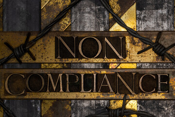 Non Compliance text over barbed wire on grunge silver with textured copper and gold background