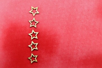 five vertical wooden stars with a red background