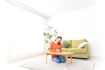 家でコーヒーを飲む若い女性