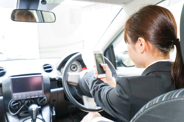 営業車で電話をするキャリアウーマン