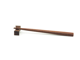 Brown wooden chopsticks on chopstick-rest isolated. Use for home or restaurant, food design. Kitchen accessory. Japanese style.