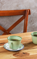 Green Enameled Cup on Wooden Table, Concept of Traditional Rustic Afternoon Tea. Copy Space for Advertisement