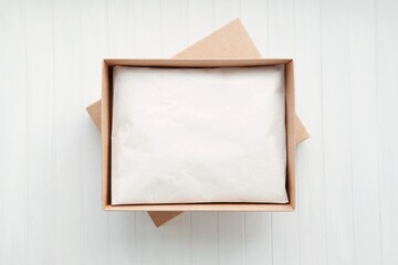 Open cardboard box with packaged product, kraft paper box mockup with gift inside.