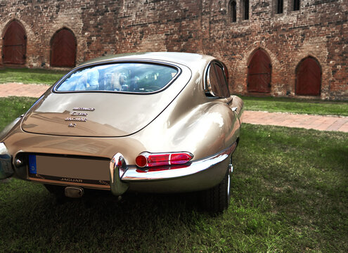 Jaguar E Type 4.2 rear view of the classic engish sports coupe in front of a medieval brick building in Lehnin, Germany, August 21, 2021