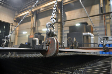 Lifting chains and hooks for loading sheet metal.