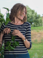 Elder Italian woman in striped clothes enjoying the vibes in a park