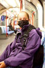 Fototapeta premium New normal. Young teenage girl with face covering mask on the subway. Mask against covid, pandemic. Teenager with face mask.