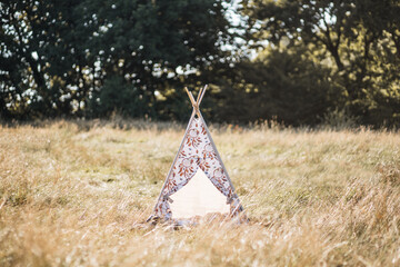 Teepee wigwam with sleep catchers pictures, outdoors in the summer field. Horizontal shot with copy space. Native American style tee-pee tent in the nature © Sofiia Shunkina