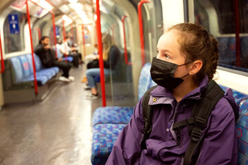 Fototapeta na wymiar New normal. Young teenage girl with face covering mask on the subway. Mask against covid, pandemic. Teenager with face mask.
