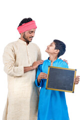 Education concept : Indian farmer with his child showing blank chalkboard on white background.