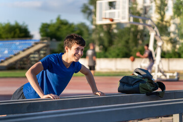 a guy on the edge of the stadium field does a push-ups, healthy lifestyle