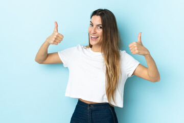 Young caucasian woman over isolated background giving a thumbs up gesture