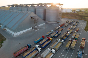 Grain terminals of modern sea commercial port. Silos for storing grain. Many trucks are waiting in...