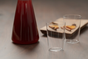 Mulled wine in glass carafe and tumbler glasses on walnut table