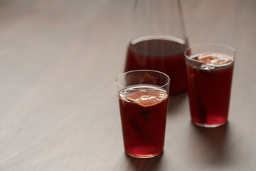 Mulled wine in tumbler glasses on walnut table with copy space