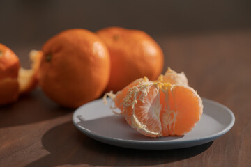 Peeled tangerines on a walnut wood table