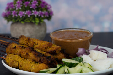Satay is skewered meat on a bamboo stick then grilled on charcoal fire eaten with peanut gravy. Satay is a famous street food in South East Asia. Selective focus