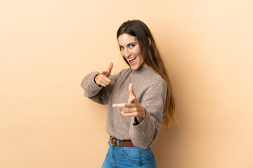 Young caucasian woman over isolated background pointing to the front and smiling