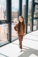 Portrait of a beautiful little girl in brown home clothes.