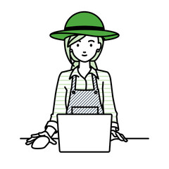 デスクで座ってPCを使っている農家の女性