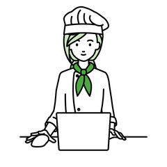 デスクで座ってPCを使っている調理師の女性