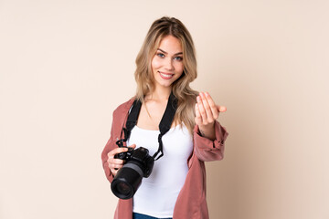 Young photographer girl over isolated background inviting to come with hand. Happy that you came