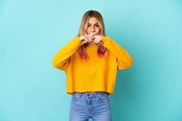 Young woman over isolated blue background showing a sign of silence gesture
