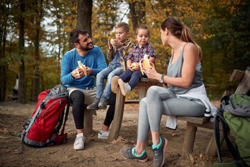 A couple and their children having a snack in the forest