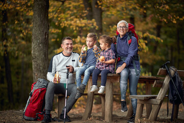 An elderly couple and grandchildren posing for a photo in the forest