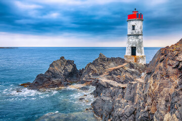 Fototapeta na wymiar Dramatic gloomy view of Capo Ferro Lighthouse.