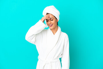 Young woman in a bathrobe over isolated blue background laughing