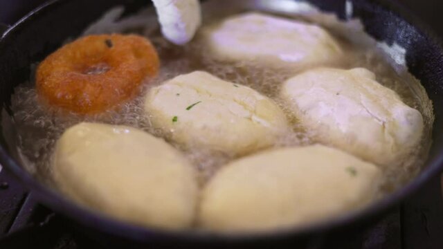 pies are cooked in a pan in oil