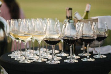 Vine glasses with red and white vine served on terrace. Outdoor catering concept. Open air party