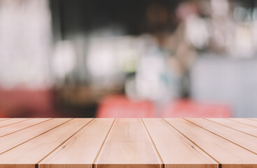 Empty wooden table top with lights bokeh on blur restaurant background.