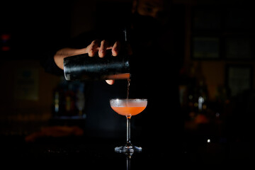 Pouring Cocktail from shaker to cocktail glass