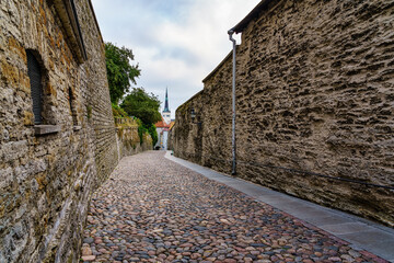 Cobbled street next to the stone walls of the city of Tallinn. Estonia.