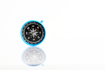 The blue compass lies on a white reflective surface. Free space for an inscription. Blank