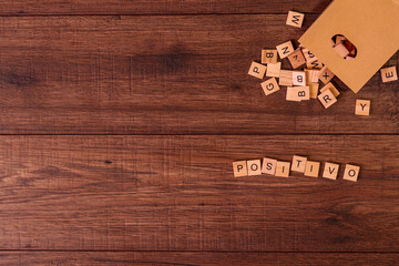 Frases motivadoras con letras de madera y una bolsa de papel con muchas fichas de letras sobre un...
