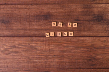 Frases de motivación con letras sobre baldosas de madera individuales con un fondo de madera...