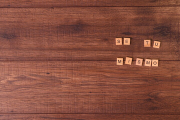 Frases de motivación con letras sobre baldosas de madera individuales con un fondo de madera...