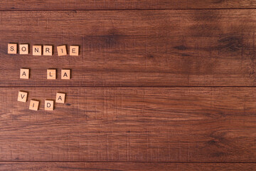 Frases de motivación con letras sobre baldosas de madera individuales con un fondo de madera...
